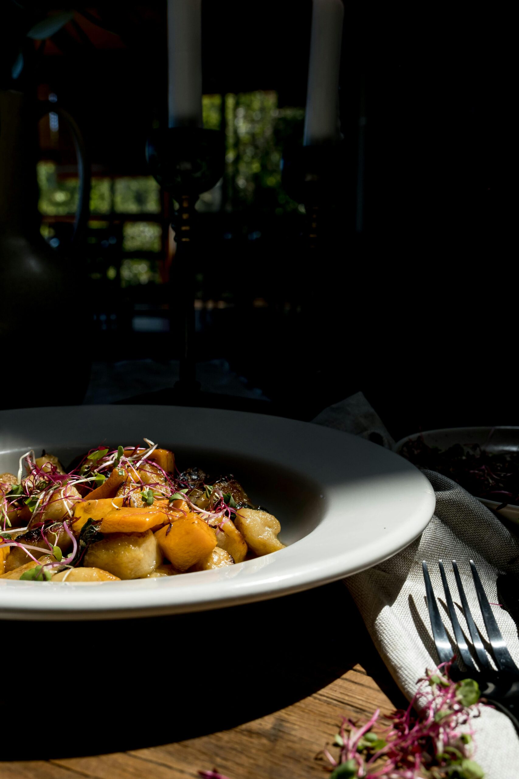 Delicious gnocchi dish garnished with fresh herbs and vegetables under warm lighting.